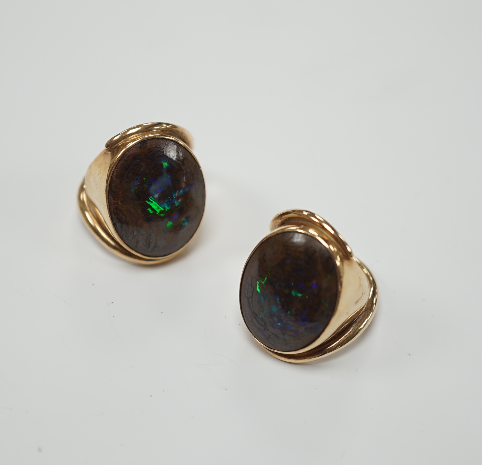 A pair of yellow metal and oval boulder opal set dress rings, both size M, gross weight 20 grams.